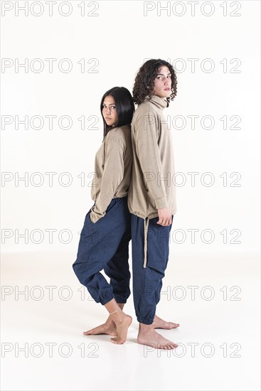 Brother and sister twins matching outfits while standing back to back