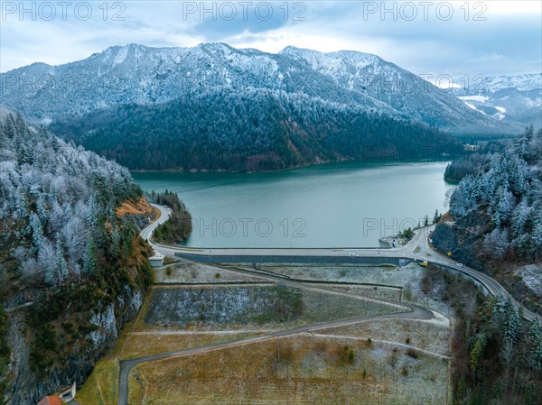 Road with dam on the water in winter