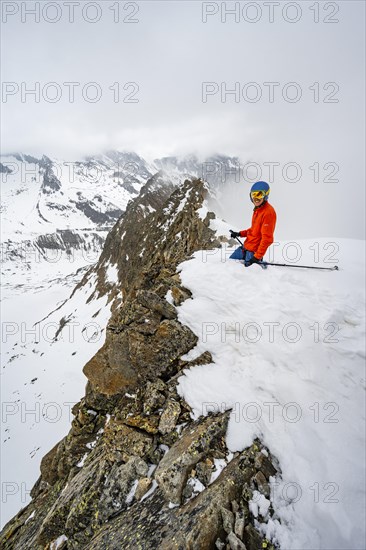 Ski tourers on rocky ridge with snow