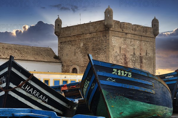 Traditional blue fishing boats in front of the fortress