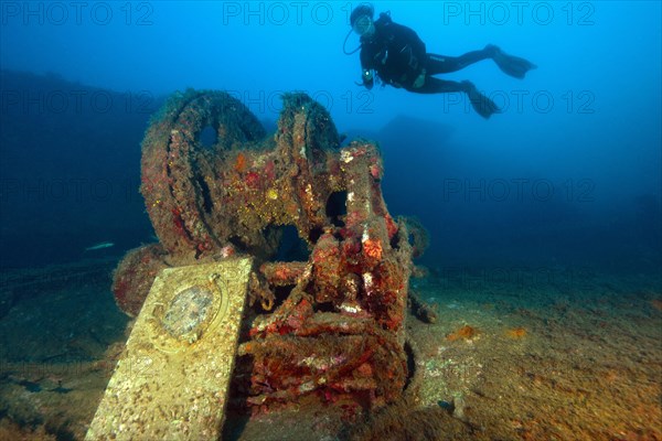 Diver dives hovering over shipwreck forecastle with windlass from wreck Mohawk Deer