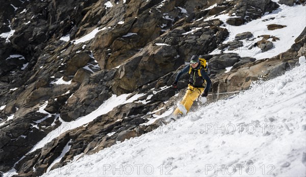 Ski tourers descending a steep slope