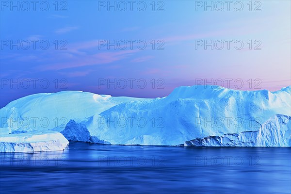 Gigantic icebergs in the light of the blue hour