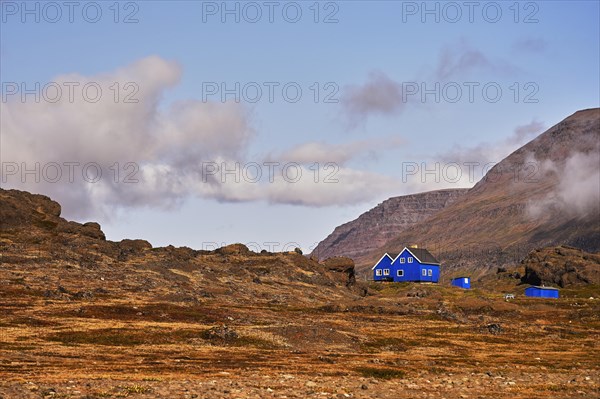 Blue wooden houses standing in volcanic landscape
