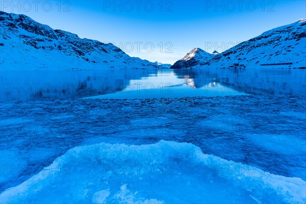 Ice structures in the black ice of the frozen Lago Bianco in the Swiss mountains