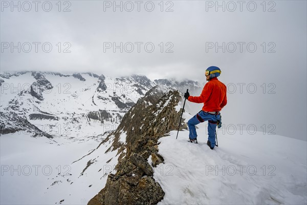 Ski tourers on rocky ridge with snow