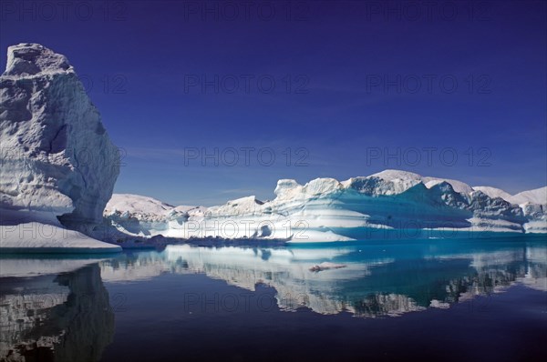 Icebergs reflected in a fjord