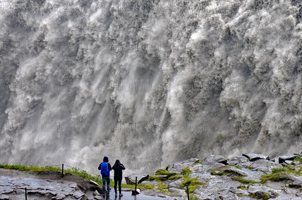 People in front of falling water masses