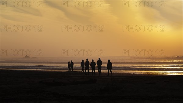 Group of tourists on the beach looking at the ruins of the watchtower Bordj El Berod on the horizon