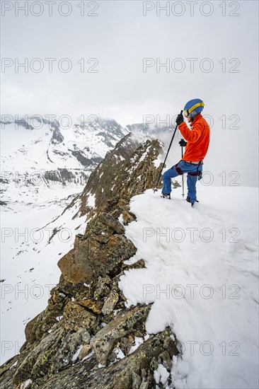 Ski tourers on rocky ridge with snow