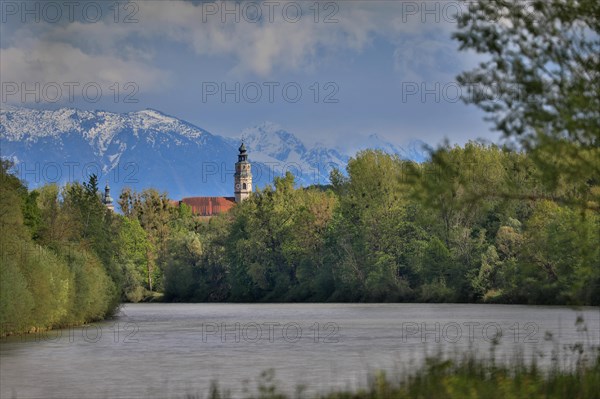 Church above a river in front of mountains