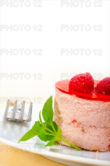 Fresh raspberry cake mousse dessert round shape with mint leaves