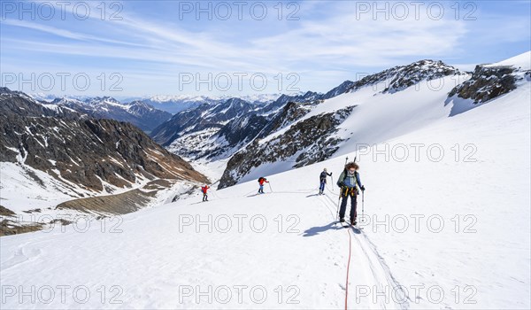 Ski tourers walking on the rope on the glacier