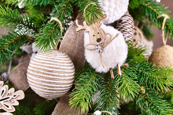 Natural Christmas tree ornament bauble made from beige and white jute rope and sheep ornament on tree branches