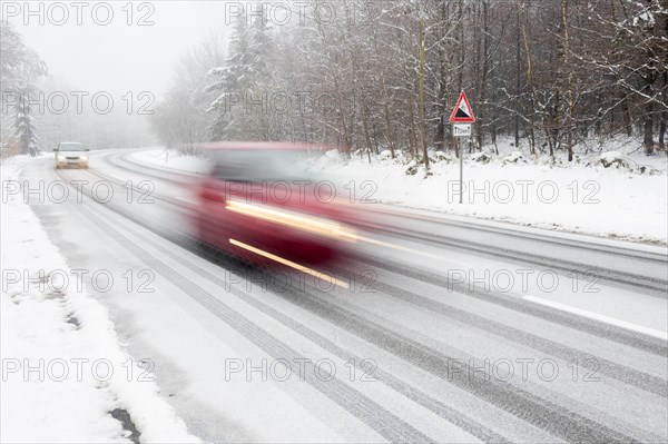 Two cars driving on snow-covered road