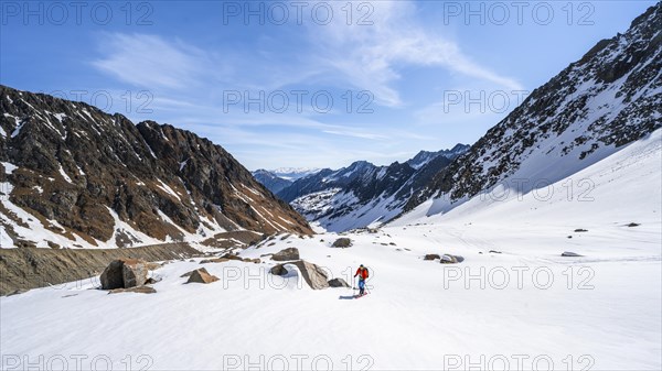 Ski tourers ascending along the glacier moraine to Berglasferner