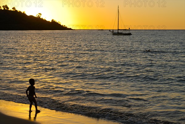 Little boy at sunset on the shores of the island of Nosy Kombe