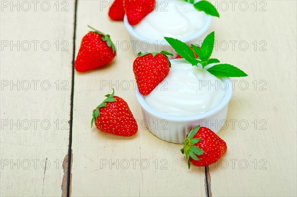 Organic Greek yogurt and strawberry over white rustic wood table