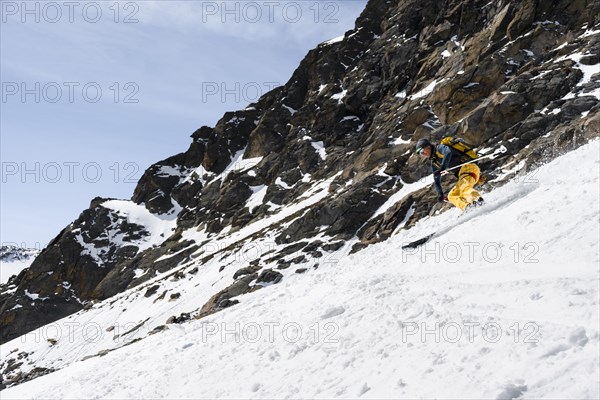 Ski tourers descending a steep slope