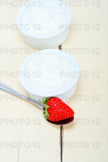 Organic Greek yogurt and strawberry over white rustic wood table