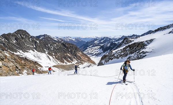 Ski tourers walking on the rope on the glacier