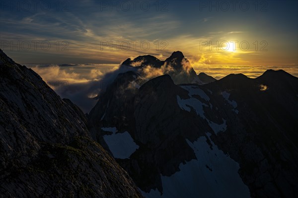 Altmann summit with yellow cloud wisps at sunrise