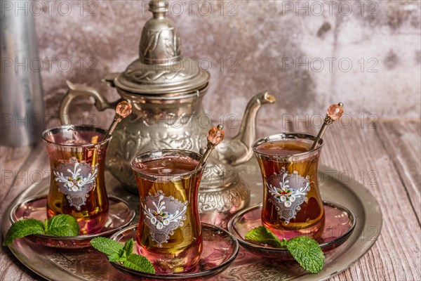 Tray with glasses and serving pitcher of authentic Moorish tea ready to drink with mint leaves