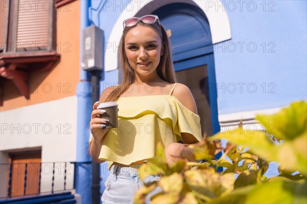 Blonde woman in houses with blue colorful facades
