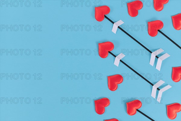 Valentine's day flat lay with cupid's love arrows on blue background with copy space