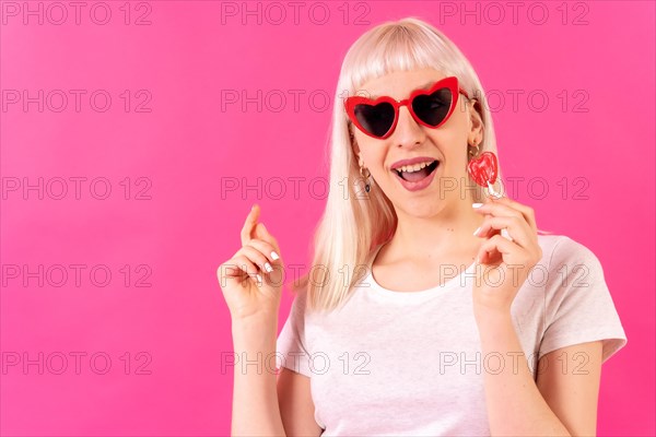 Blonde caucasian girl in studio on pink background