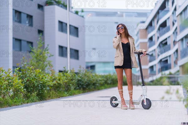 A businesswoman moving with an electric scooter around the city