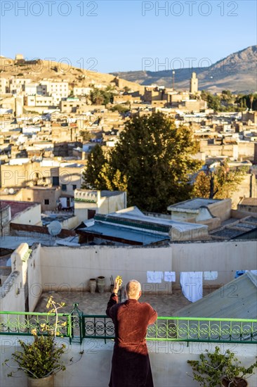Man on the rooftop enjoying view of Fez old arabic medina
