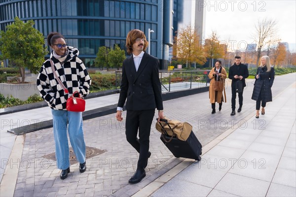 Group of multi-ethnic business people with suitcases attending a conference in a business park