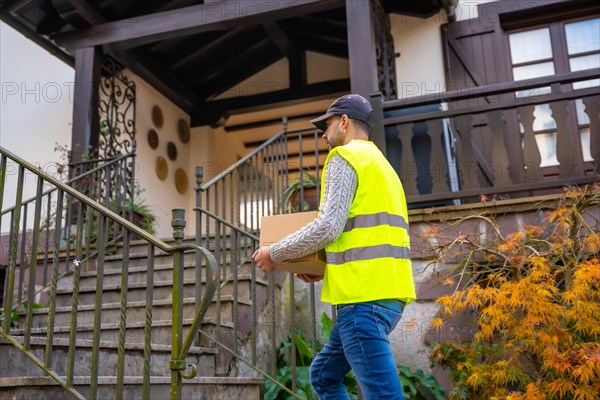 A young delivery man in a protective uniform at the delivery of the online order