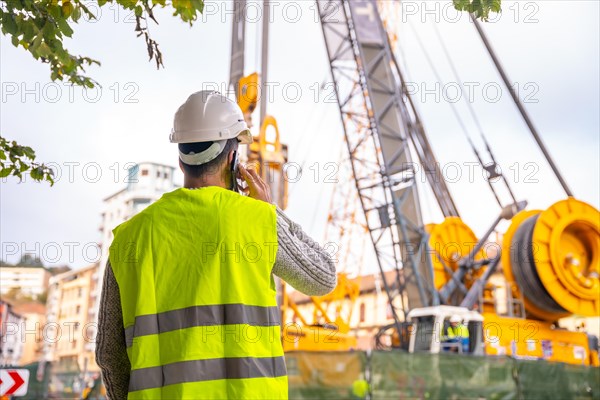 Technician engineer observing the team of workers at the construction site in the city