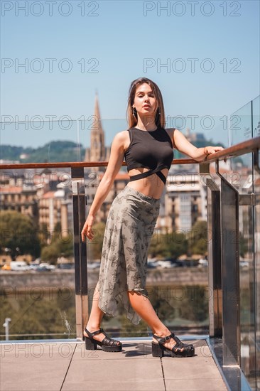 Portrait of a young woman on a hotel terrace looking at the city from above