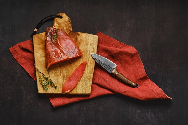 Top view of air dried turkey breast on wooden cutting board with place for text