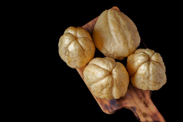 Chayotes isolated on a black background on a wooden board