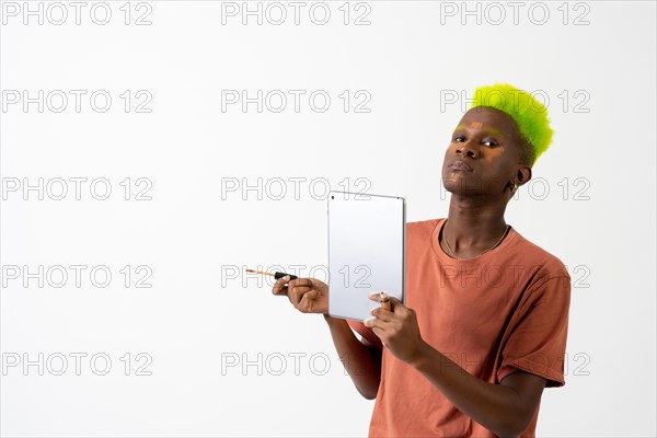 A gay black ethnic man putting on makeup