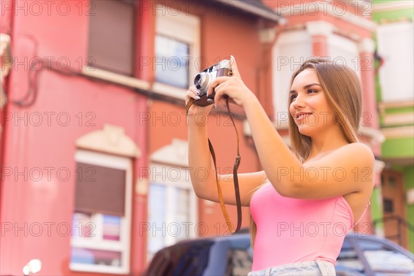 Blonde tourist in a neighborhood with a street with houses with colorful pink facades