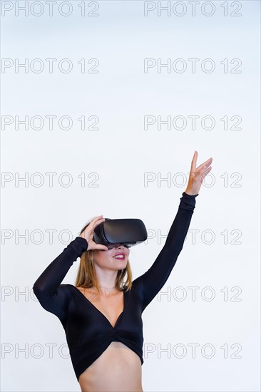 Woman wearing virtual reality goggles on white background