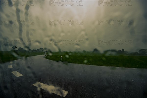 Road and meadows with thunderstorm sky in the background