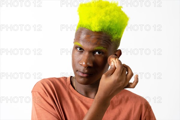 An androgynous black man posing putting on makeup