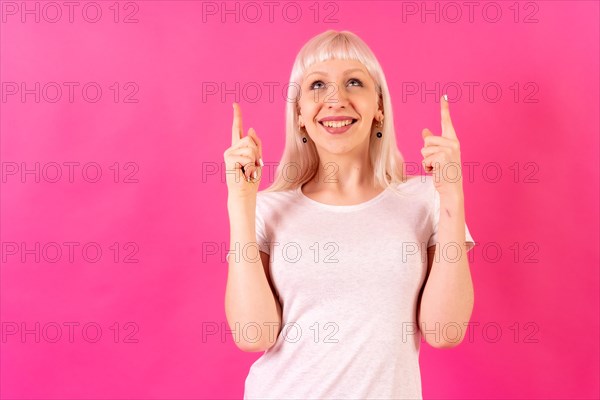 Blonde caucasian girl on pink studio background