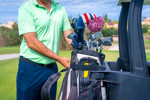 Man caucasian in the Buggy with the bag of clubs playing golf