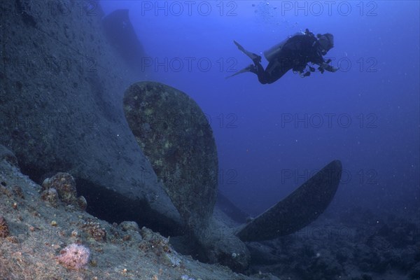 Thistlegorm propeller from the Second World War on the seabed. Divers in the background. Dive site Thistlegorm wreck