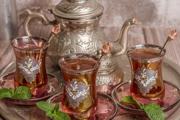 Tray with glasses and serving pitcher of authentic Moorish tea ready to drink with mint leaves