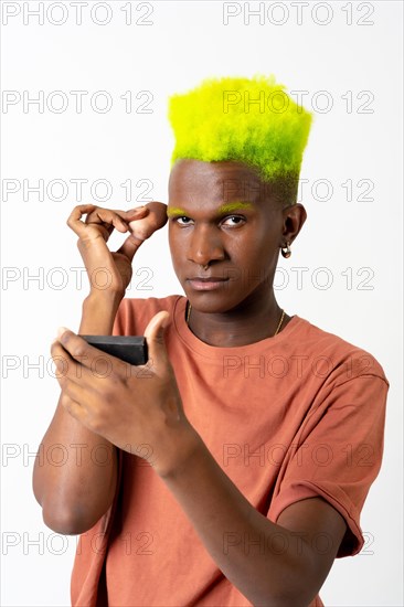 An androgynous black man posing putting on makeup