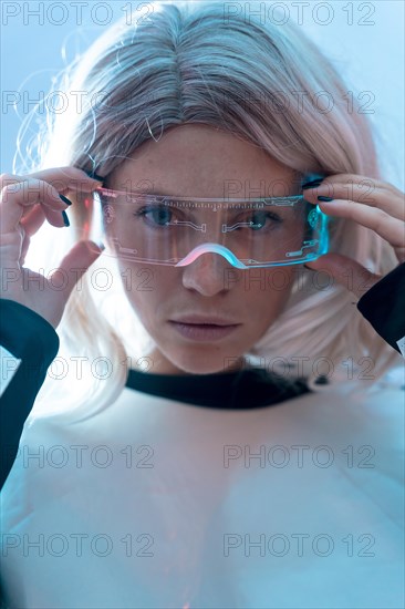Woman looking with the illuminated futuristic glasses