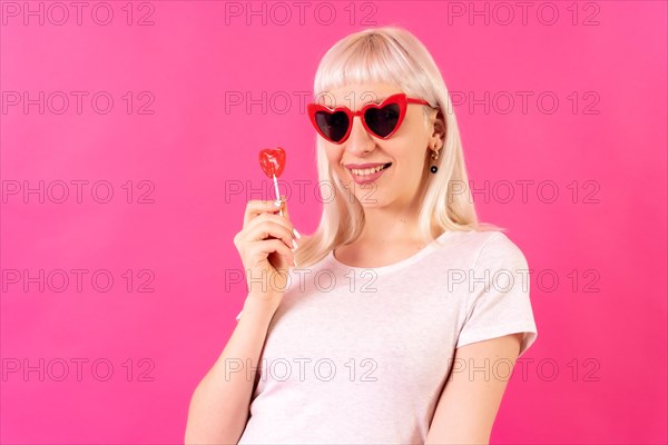 Blonde caucasian girl in studio on pink background